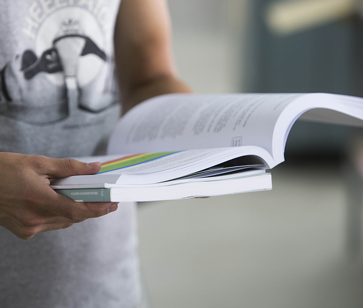 En person som håller i en uppslagen bok